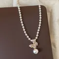 Elegante Detailansicht einer Perlenkette mit einem rosa Zirkon-Schmetterlingsanhänger. - Schmetterling-Perlenhalskette