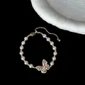 Detailansicht eines eleganten Perlenarmbands mit rosa Kristall-Schmetterlingsanhänger. - Schmetterling Perle Armband