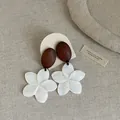 Detail view of vintage wood and white shell plumeria flower drop earrings - Style 10 Earrings