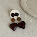 Detailed macro view of vintage heart-shaped wooden earrings with multi-tone brown textures. - Style 7 Earrings