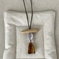 Detailed view of a retro geometric resin pendant necklace with amber Maillard style aesthetic - Style 5 Wood Striped Amber Necklace