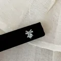 Detailaufnahme eines zarten minzgrünen Zirkon-Sternohrsteckers mit einer silbernen Schleife - Stern Schleife Stil / 1 Stück