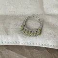 Nahaufnahme eines silbernen Rings mit grüner Fadenwicklung und Hammerschlag-Struktur. - Grüne Linie Schmaler Ring