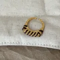 Detailansicht des strukturierten Goldrings mit eleganter brauner Fadenumwicklung. - Rotbraune Linie Schmaler Ring