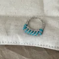 Detailaufnahme eines silbernen Rings mit türkisfarbener Fadenwicklung - Blaue Linie Schmaler Ring
