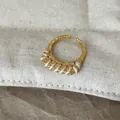 Detailansicht eines strukturierten Goldrings mit einer einzigartigen weißen Fadenwicklung. - Weiße Linie Schmaler Ring