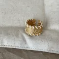 Detailansicht eines goldenen Metallrings mit Struktur und weißem geflochtenem Faden am Rand - Lockere Passform / Weiße Linie Breiter Ring