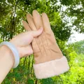 Close-up detail of warm camel suede gloves with plush pink faux fur cuffs for women. - Three-Strand / Khaki