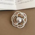 Close-up detail of the elegant tweed camellia flower brooch with a large central pearl - Style 1