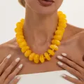 Vibrant yellow chunky resin beaded necklace with gold CCB spacers shown on a model - Yellow