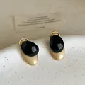 Detalle de primer plano que muestra la textura de los aretes de gota de aceite ovalados negros - Negro y Dorado / Dorado