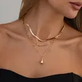 Détail d'un collier doré multicouche avec chaîne serpent plate et pendentif goutte - Style Doré (07399)