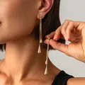 Elegant minimalist long gold tassel earrings with teardrop pendants worn by model closeup - Earrings (4122) / Gold