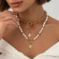 Gros plan d'un ensemble de colliers dorés vintage avec perles baroques et pendentif portrait - Style Relief Portrait Chaîne Cuba Trois Rangs (07250)