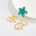 Primer plano de anillos dorados para el pie con flor de esmalte azul y estrella de mar. - Oro Claro Juego de 4 Piezas