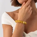 Elegant bohemian swirled amber resin beaded bracelet with gold spacers on female model - Earth Yellow Bracelet (3199)