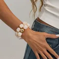 Vintage resin bead bracelet with marble swirl and gold-tone spacers on a model. - Gold+White