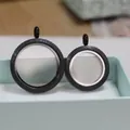 Detail view of round black glitter glass locket pendants in two different sizes. - 30mm / Black