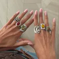 Close-up detail of model wearing French retro silver rings with colorful gemstones and carvings - French Vintage (7453) / Antique Silver