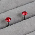 Elegant red faceted birthstone stud earrings on durable titanium steel posts shown on grey velvet - Ruby Red (July)