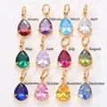 Set de 12 dijes de piedra de nacimiento en forma de pera con engaste de garras oro. - Marzo (Circonia Aguamarina) / Oro (Tipo abierto)