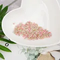 Primer plano de perlas de imitación ABS rosas y verdes en plato de corazón - Multicolor Rosa Blanco Verde Claro