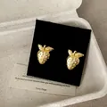 Squisiti orecchini a lobo a forma di fragola in metallo dorato in una confezione regalo minimal - Orecchini a lobo / Oro