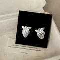 Dettaglio ravvicinato di orecchini a lobo a forma di fragola in metallo argentato. - Orecchini a lobo / Argento