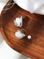 Detailed close-up of a classic magnolia flower brooch with pearls and crystals on wood - Silver Style (A23-199) / Silver