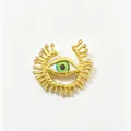 Detailed macro view of an ornate gold evil eye brooch with green iris and crystals - Hammered Ray Eyelash Eye Style (Y5)