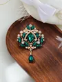 Close-up of a luxury vintage emerald green crystal brooch pendant on a dark wooden tray - Emerald Green Style (A17-38)
