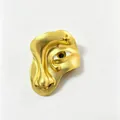 Detailed macro view of a surrealist golden face brooch with a realistic evil eye - Surreal Irregular Face Style (Y10)