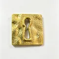 Detailed macro view of a vintage gold hammered square brooch with a surrealist keyhole cutout - Surreal Large Keyhole Style (Y12)