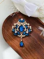 Detail view of an elegant vintage-style gold brooch featuring royal blue pear-cut crystals. - Deep Blue Gold Style (A17-39)