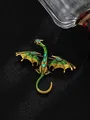Detailed close-up of a vintage green enamel dragon brooch with blue rhinestone accents. - Dark Green