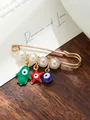 Detailed view of a golden safety pin brooch featuring white pearls and evil eye charms - Red Black Blue Multi-Color Pendant Style (my4)