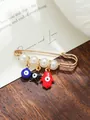 Detailed macro view of gold evil eye and Hamsa hand brooch pin decorated with white pearls - Black Red Blue Classic Amulet Style (my8)