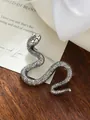Primer plano de un broche de serpiente de plata vintage sobre fondo madera - Estilo de Serpiente (A23-53) / Plateado