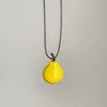 Detalle de un creativo collar con colgante de pera amarilla y cordón negro minimalista. - Pera Amarilla / S