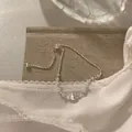 Detailopname van een zilveren trekkoordsierlijk armbandje met een geborstelde kogel - Trekkoord Armband / Zilver