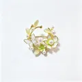 Detailopname van de bloemenkrans broche met parels en vlinders van glanzend emaille - Groen
