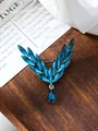 Exquisite close-up of blue crystal angel wing brooch displayed on a rustic wooden tray. - Blue (A9-47)