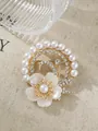 Detail einer eleganten goldfarbenen Brosche mit Perlen, Strass und weißem Blumenmuster. - Vintage-Perlmutt-Blüten-Stil (A22-56)