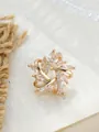 Detailansicht einer eleganten goldenen Blumenbrosche mit funkelnden Marquise-Kristallen - Blumen-Schneeflocken-Stil (A22-107)