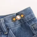 Close-up of decorative black daisy waist button with gold base for adjusting denim jeans fit - Gold Black Base Daisy (No. 3) / Gold