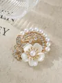 Nahaufnahme einer eleganten Blumenbrosche mit weißen Perlen und funkelnden Steinen - Schmetterling Perle Strass Stil (A22-49)