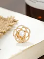 Nahaufnahme einer goldfarbenen Kamelien-Brosche mit einer eleganten zentralen Perle - Hohl Twist Kamelie Stil (A23-19) / Gold