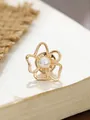 Nahaufnahme einer eleganten goldenen Kamelienblüten-Brosche mit Perlendetail in der Mitte - Glänzende goldene Gitter-hohle Kamelie (A23-27)