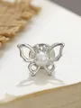 Makro-Detail einer silbernen Schmetterlingsnadel mit Perle auf einer Buchoberfläche - Silberner Perlen-Schmetterlingsverschluss (A23-30)