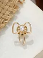 Nahaufnahme einer eleganten goldenen Brosche in Schleifenform mit weißem Perlendetail - Schleifen-Stil (A23-31) / Gold